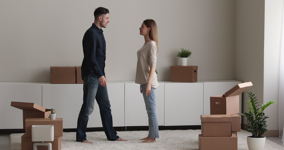 Affectionate loving young man lifting in air smiling woman, celebrating purchasing new apartment. Happy loving millennial family couple cuddling, spending time together in own dwelling, moving day. Royalty-Free Stock Footage #1082083937