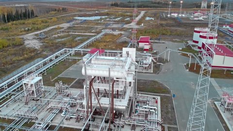 The drone flies over industrial buildings, pipelines and storage tanks for oil and gas. Oil and gas fields in Canada or Russia. In the northern latitudes of the tundra.