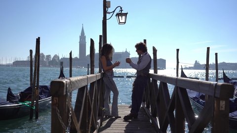 Italy - 40-year-old man and girlfriend on a love journey in Venice - Marriage proposal with ring and kiss in the city of love - request to get married on a wooden bridge in the Venice lagoon