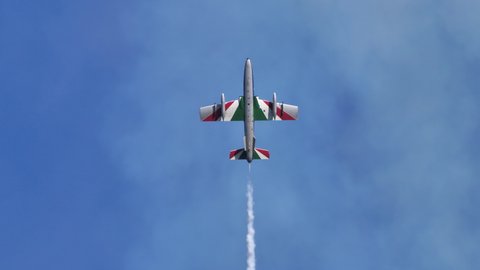 Thiene Vicenza Italy OCTOBER, 16, 2021 Military plane rises vertically into the blue sky, stops and falls back into its white smoke like a bell. Aermacchi MB-339 of Frecce Tricolori aerobatic team