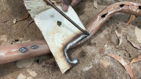 Gas welding of metal pipe. Gas cutter with copper nozzle with a stream of fire directed at the metal. Heating up the metal with a gas cutter.