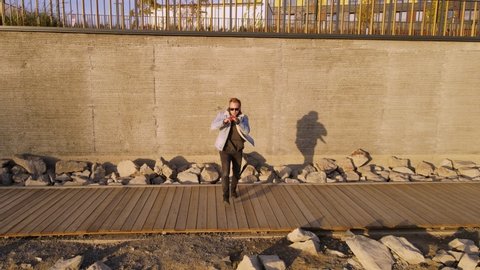 Man dancing footfork on the background of a concrete wall. Horizontal harness on a quadcopter. Autumn outdoor dancing