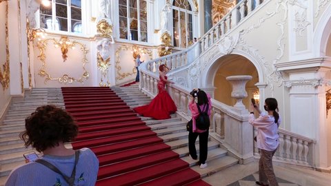 Saint Petersburg, Russia, May 11, 2021. Winter Palace in St. Petersburg. Hermitage Museum interior. On the Jordan Stairs, a young woman poses for a photographer.