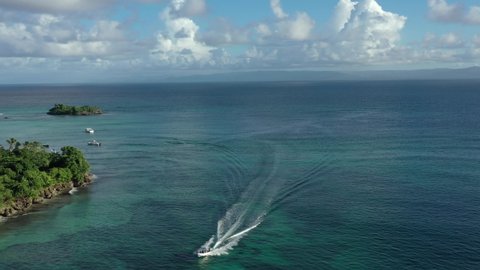 Speedboat sailing on turquoise waters of Cayo Levantado island in Dominican Republic. Aerial drone view