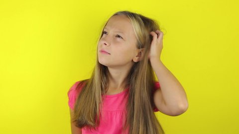Girl scratches her head on a colored background