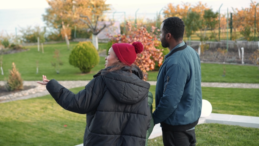 Back view of an African family standing on the terrace near the house