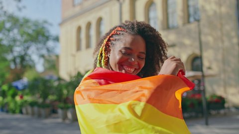 Young african american female supporting lgbt community, holding rainbow flag
