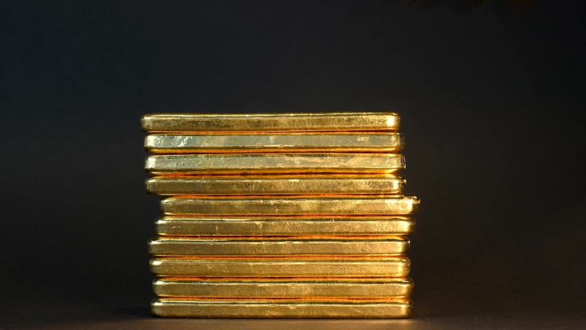 Stack of 1 kilo pure gold bullion bars on black background. Hand in black glove removing  golden ingots one by one. Royalty-Free Stock Footage #1082123114
