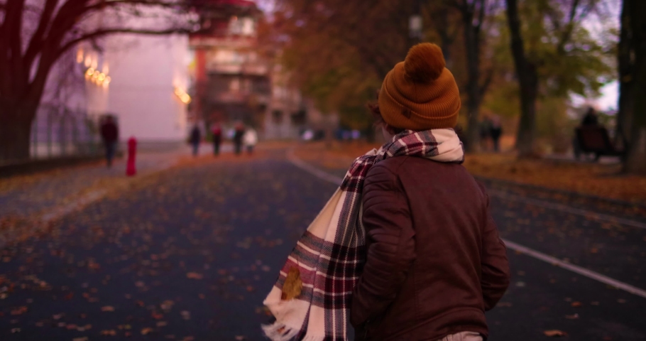 chasing a happy kid, that is running along the autumn city street