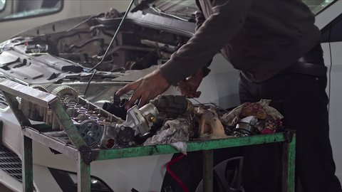 Mechanic Checking Car's Defective Turbocharger At Car Repair Shop
