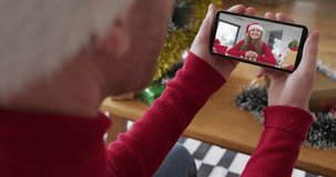 Caucasian man with santa hat using smartphone for christmas video call with smiling woman on screen. christmas, festivity and communication technology.
