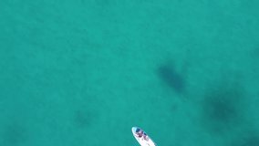 Aerial view video of active family on SUP stand up paddle vacation. Parents and children enjoying summer vacation on paradise Mediterranean beach in Adriatic Sea, Silba, Croatia.