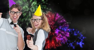 Animation of happy couple in glasses celebrating, over happy new year text and colourul fireworks. new year, celebration, party, tradition and event concept digitally generated video.