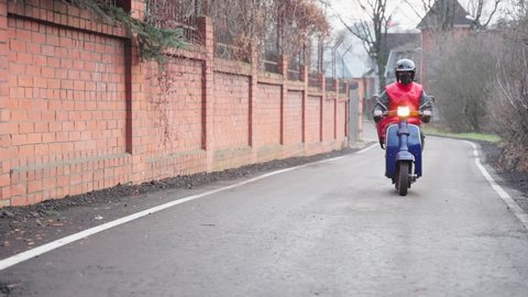Courier delivering parcel box by motorcycle or scooter. Fast express transport delivery concept. Working in a pandemic