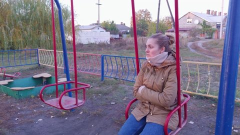 Upset woman on a swing autumn outdoors