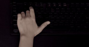 Сhildren's hand on the keyboard. Playing online game.