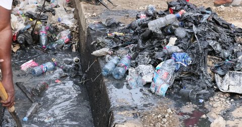 NIMA, GHANA - 30 OCT 2021: Garbage Trash sewer ditch drain poverty area Accra Ghana. Busy congested market residential area environment. Pollution and garbage. Low income poverty of Africa. 