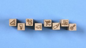 Wooden blocks with Advertising, Target, Shopping Cart, Light Bulb and Graph icons moving to the center. Concept of Marketing and Strategy. Seamless looping. Blue background. High quality 4k video - Powered by Shutterstock - Get 15% off with code: PIKWIZARD15