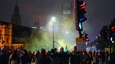LONDON - NOVEMBER 5, 2021: Crowds of protesters at The Million Mask March with smoke in Parliament Square