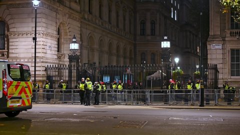 LONDON - NOVEMBER 5, 2021: Large group of armed Police guarding entrance to Downing Street at night during Million Mask March