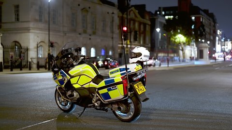 LONDON - NOVEMBER 5, 2021: Mounted Police pass Police motorcycles at entrance to Horse Guards Parade at Million Mask March at night