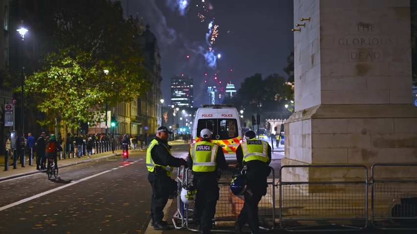 LONDON - NOVEMBER 5, 2021: Riot Police and a Police van next to The Cenotaph on Whitehall with fireworks in the background at Million Mask March