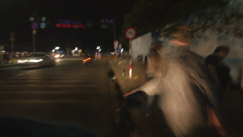 Hyper lapse of bike driving on the night streets of Vietnam. Motion blurred night illumination. Scooter fast driving. Dynamic motorcycle speed riding.