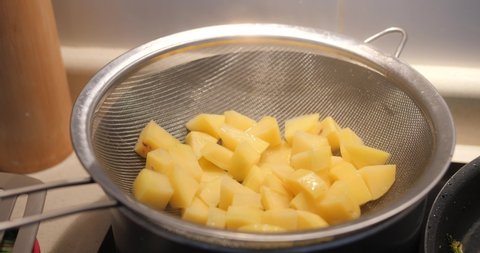 Chopped Peeled Potatoes Steaming In A Pot With Colander. close up