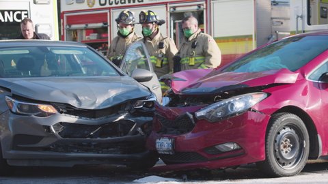 Ottawa, Ontario, Canada - November 2021 : A multi car accident during COVID-19 pandemic is handled by first responders wearing safety equipment to curb the spread of the deadly virus