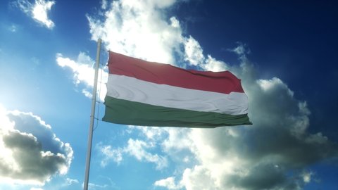 Flag of Hungary waving at wind against beautiful blue sky