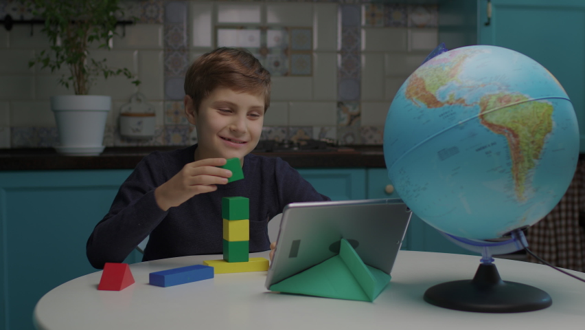 Autistic boy building with color wooden blocks using tablet computer. Online assignment to pupil with autism. Applied behavior analysis for students with autism. Royalty-Free Stock Footage #1082187671