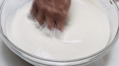 Close up slow motion view of Dosa batter mixed by Indian lady.Dosa is very popular  south Indian breakfast.