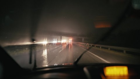 Driver point of view driving car at night in rain with wipers 4K