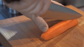 Sliced ​​carrots into slices, macro shot  the process of cutting the ingredients for the soup on wooden cutting board.  Healthy eating. Selective focus on vegetables
