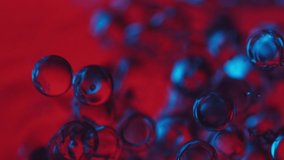 calming video of spheres floating in water in red and blue light