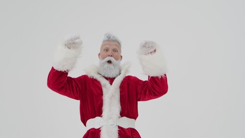 Handsome old cheerful Santa Claus with funny face actively gesticulate looking at camera, Christmas and New Year time, using mobile application and technology in modern life, web surfing internet.