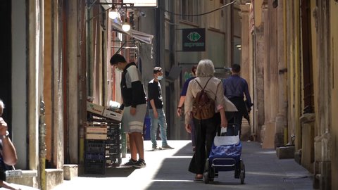 Genoa, Italy - September 20 2021: Genoa historical center with the sun filtering through the buildings.
Slow motion of people strolling through the alleys of the historic center of Genoa.
