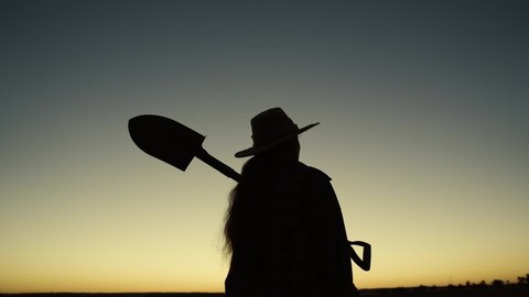 silhouette of farmer carries shovel on his shoulder, farming, working in field with soil soil, go to drip plantation, gardener working in garden at sunset, farm agronomist ecology nature, harvesting