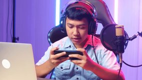 Asian Kid Boy Playing Video Game With Mobile Phone Then Celebrating While Live Stream 
