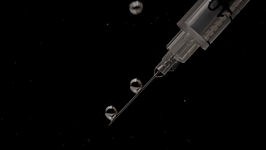 Syringe with medicine. Macro shot of Syringe with medicine in water and air bubbles on black background. The medicine concept, health care, treatment. Slow motion. - Powered by Shutterstock - Get 15% off with code: PIKWIZARD15