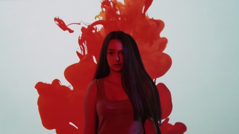 Menstruation symptoms. Monthly bleeding. PMS anxiety. Scared shocked girl suffering from irregular period pain cramp in red blood drop on white wall copy space background.