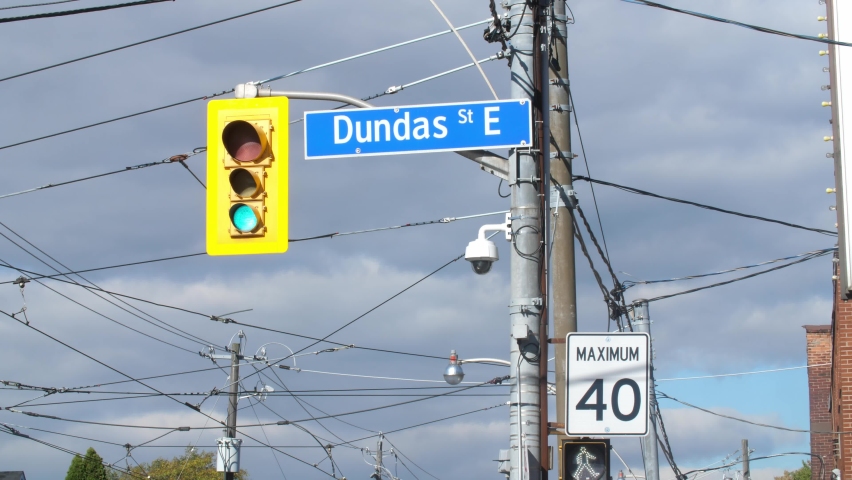 Dundas Street East sign on utility pole with stop light and 40 kmh speed limit sign. Toronto, Ontario, Canada.