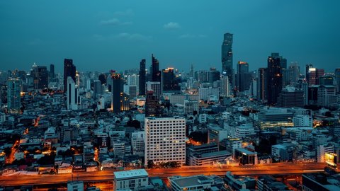 Time lapse night cityscape and high-rise buildings in metropolis city center . Downtown business district in panoramic view .