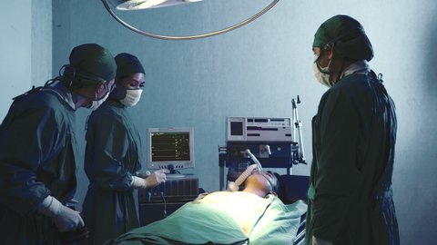 Defibrillation cardiac dysrhythmia, Surgical doctor team performing surgery patient on operating room in hospital, doctors use medical devices automated External Defibrillator to pump hearts patients