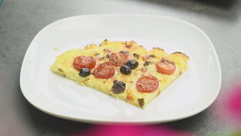 The cook serving baked polenta with cherry tomatoes.