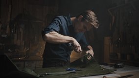 Young focused professional craftsman unpicking canvas fabric at workshop, cutting seams with knife in evening - Powered by Shutterstock - Get 15% off with code: PIKWIZARD15
