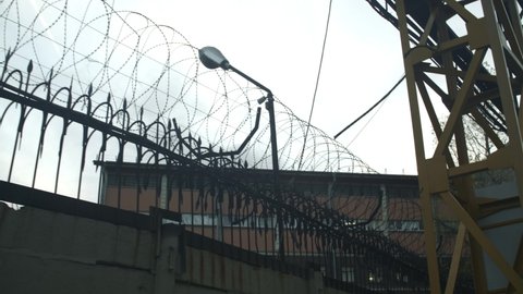 Razor wire. Barbed wire fence with sharp spears - no trespass. Prison, jail view. Declared guilty people. That prisoners can see: light blue sky and rare clouds. Crime, crackdown, illegal concept 