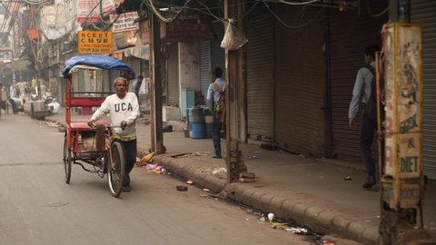 Delhi, India - Nov 12 2021: Bicycle Rickshaw ride at morning chandni chowk in old delhi, india. Morning road traffic in Chawri bazar. Street of Old Delhi. Chaotic scene inside old Delhi.