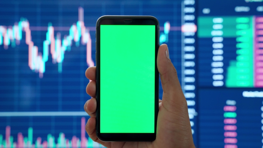 Male cryptocurrency trader investor analyst hand holding cell phone with green mockup screen doing stock market data price graphs analysis using cryptocurrency trading mobile app, stock application. Royalty-Free Stock Footage #1082263895