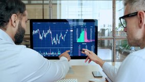 Two traders brokers stock exchange market investors discussing crypto trading charts growth using pc computer pointing at screen analyzing financial risks, investment profit forecast. Over shoulder - Powered by Shutterstock - Get 15% off with code: PIKWIZARD15